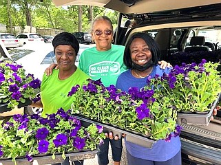 From left, Roxanne White, Janis Van Hook and Valarie Smith, all of Keep El Dorado Beautiful, deliver purple petunias to Northwest Elementary School in celebration of Earth Day. Students from Northwest and Hugh Goodwin Elementary School will receive the flowers today to plant at home as part of the annual beautification project. KEB delivered a total of 980 flowers, 500 to Northwest and 480 to High Goodwin, days after conducting a citywide Litter Index Survey.